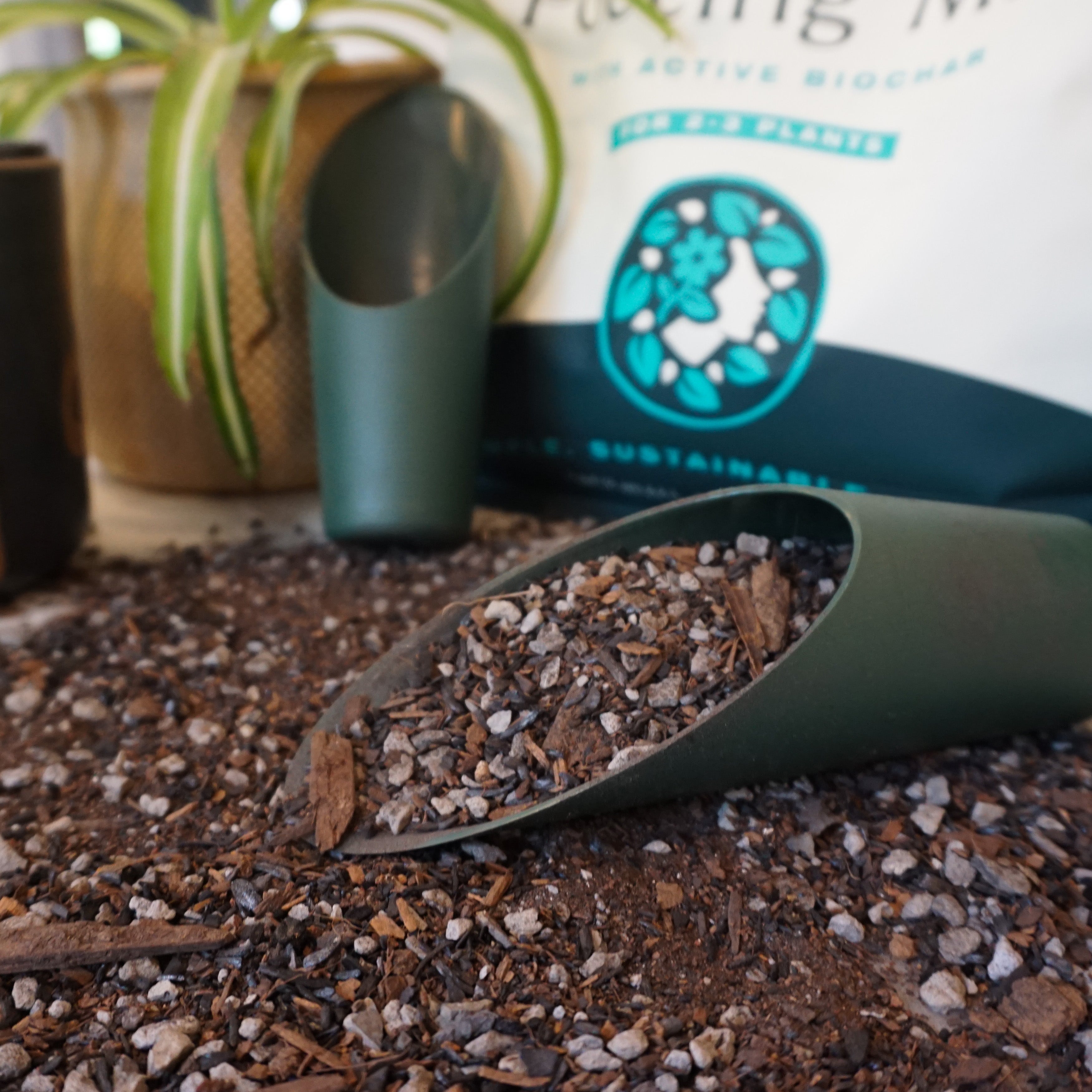 Green scoop in soil with plants and a bag labeled 'Sustainable' in the background